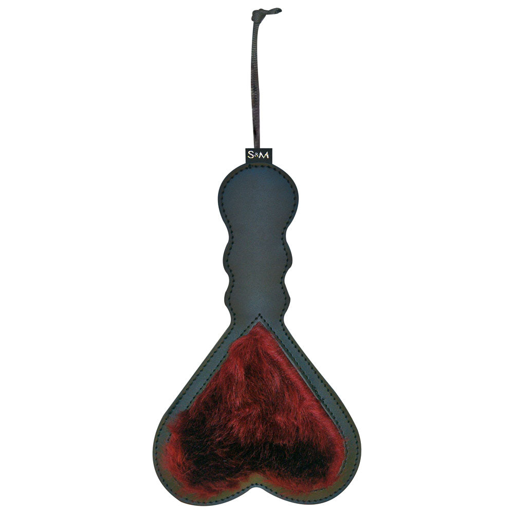 The Sex & Mischief Enchanted Heart Paddle features a dual-sided black and red design with a spade shape at the bottom. It boasts a smooth black handle that thickens towards the base, adorned with red faux fur. A looped strap is attached to the top for hanging or holding, making it an ideal BDSM accessory.
