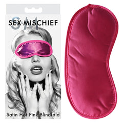 A product photo featuring a packaging box on the left with the text "Sex & Mischief Satin Blindfold Hot Pink" and an image of a woman wearing a hot pink blindfold. The satin blindfold itself, known as a BDSM essential for heightened senses, is displayed to the right of the box.