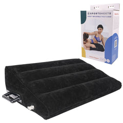 A black inflatable wedge pillow made of durable vinyl with grip handles is shown in front of its packaging, which features an illustration of a couple using the cushion in the bedroom. The packaging highlights the brand "Sportsheets" and the product name "Pivot Inflatable Positioner Sex Cushion.
