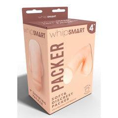 The image shows a beige and pink box of a WhipSmart 4'' Soft & Discreet Packer - Flesh 10.2 cm Packer. The text on the box describes it as an ultra-realistic, lifelike packer. A partial image of the product, showcasing its realistic bulge, is visible on the left side of the box.