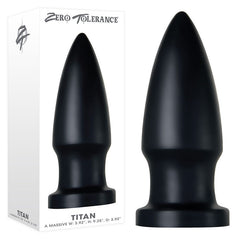 A large, bullet-shaped anal plug with a powerful suction cup base is displayed next to its packaging. The brand "Zero Tolerance" is prominently featured at the top, with the product name "The Titan Butt Plug" at the bottom. With dimensions of Width 3.92 inches, Height 9.25 inches, and Diameter 3.92 inches, it is ideal for advanced anal play enthusiasts.
